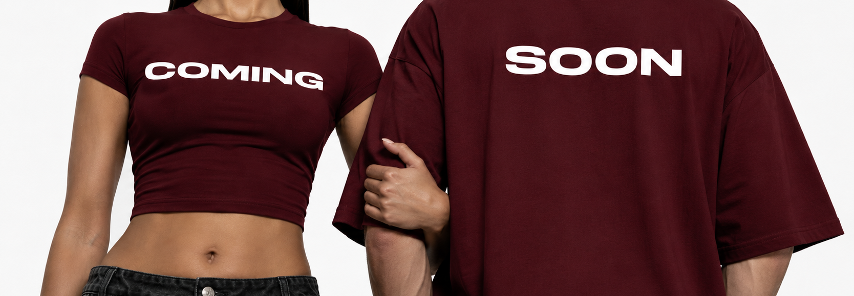 Two people wearing maroon t-shirts with 'COMING' and 'SOON' text on a plain background